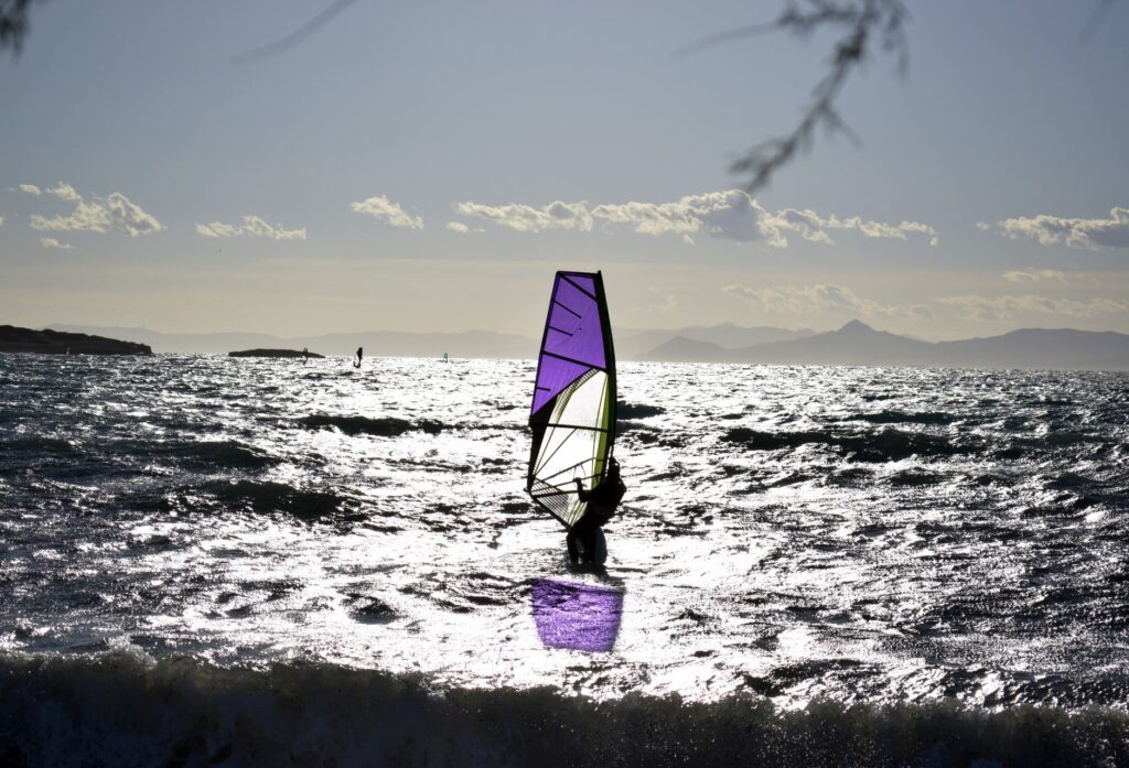 Vasilis, a 58 years old man, practising windsurfing on waves of Voula bay, during the cold weather. 
His first contact with the sport was at the age of 17. 
Voula is an area located by the beach at the southern part of Athens. For many years now, Voula remains one of the most popular beaches at the suburbs of Athens.